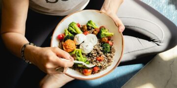 Vrouw houdt een kom met gezond eten vast